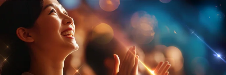 A woman smiling and clapping in admiration while looking upwards, surrounded by colorful bokeh lights in warm and cool tones, creating a festive and joyful atmosphere.
