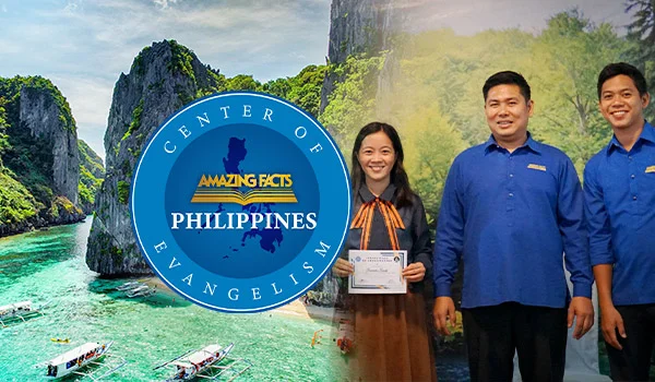 A smiling woman holding a certificate stands next to two men in matching blue shirts, all posing for a photo indoors. To the left, a circular logo features a map of the Philippines and the text "Center of Evangelism – Amazing Facts Philippines." The background includes a scenic tropical view of limestone cliffs and turquoise waters with small boats, representing the Philippines' natural beauty.